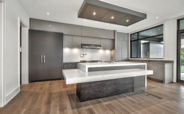 Kitchen with a large island, flush cabinetry and a recessed ceiling feature