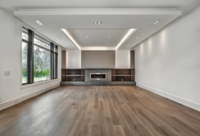 Open living room with a linear fireplace and recessed ceiling lighting