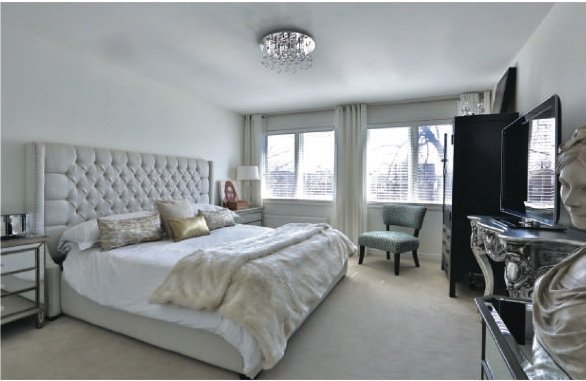 Bedroom with a tufted headboard and framed windows