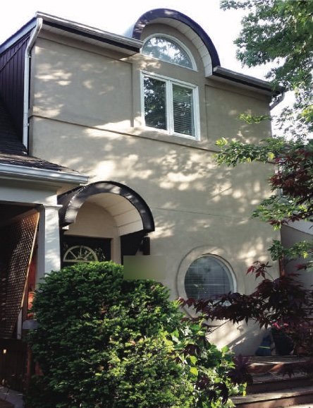 Front of the house before the exterior work, with an arched entrance and stucco facade