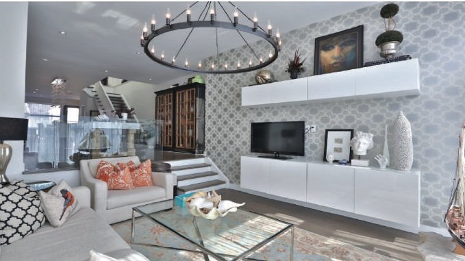 Living area with a patterned feature wall and a chandelier